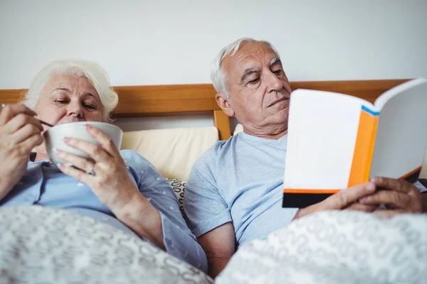 Man läsa romanen och kvinna ha frukost — Stockfoto