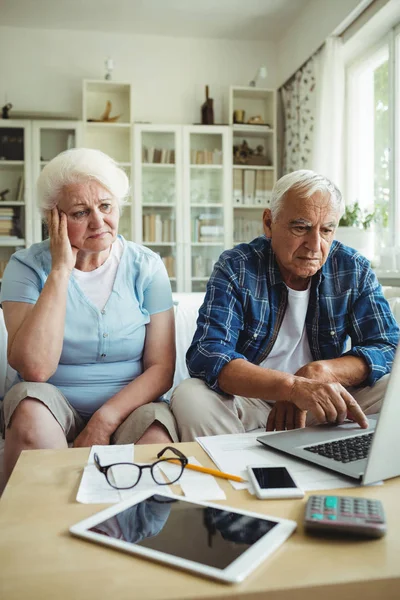 Preocupado pareja de ancianos utilizando el ordenador portátil —  Fotos de Stock