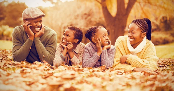 葉に笑みを浮かべて家族横たわって — ストック写真