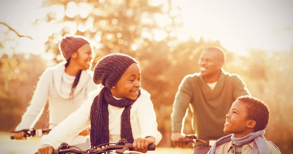 Sonriente familia haciendo un paseo en bicicleta — Foto de Stock