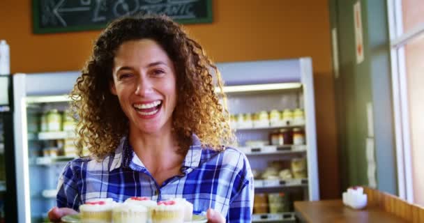 Усміхнена жінка тримає кекси — стокове відео