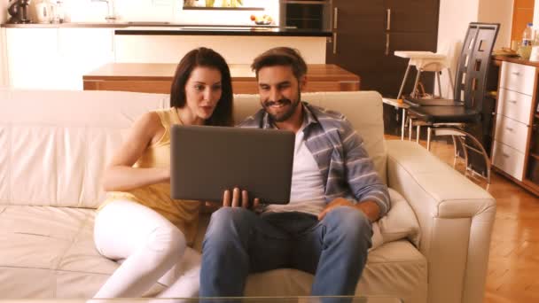 Couple sur canapé à l'aide d'un ordinateur portable — Video