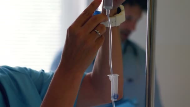 Nurse injecting medicine in infusion — Stock Video