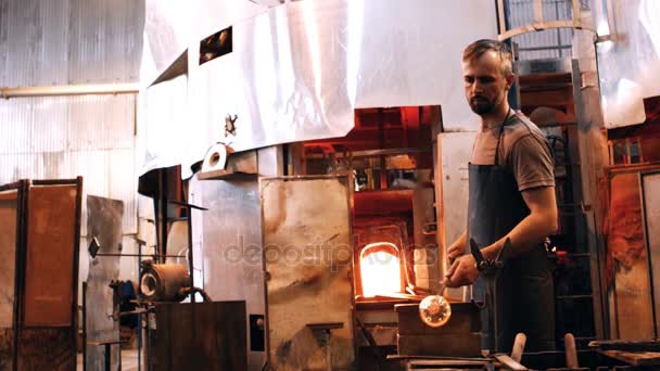 Glassblower shaping molten glass — Stock Video