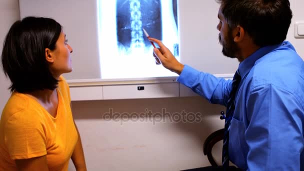 Doctor discutiendo rayos X con el paciente — Vídeos de Stock