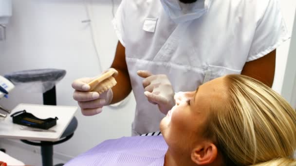 Dentista che mostra i denti modello al paziente — Video Stock