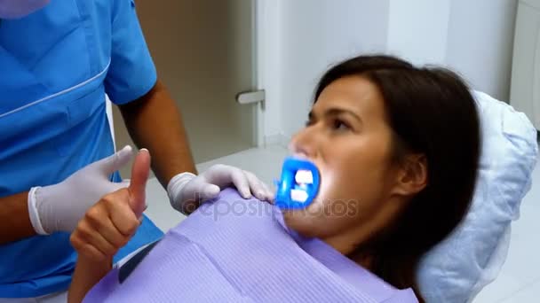 Dentista interactuando con paciente femenino — Vídeos de Stock