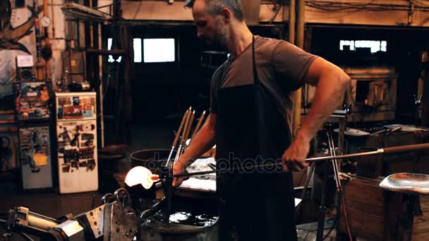Glassblower forming and shaping molten glass — Stock Video