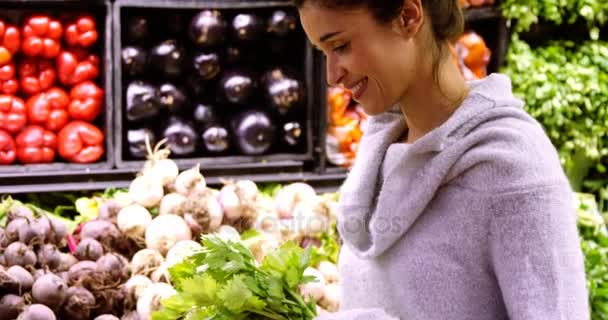 Leende kvinna köpa bladgrönsaker — Stockvideo