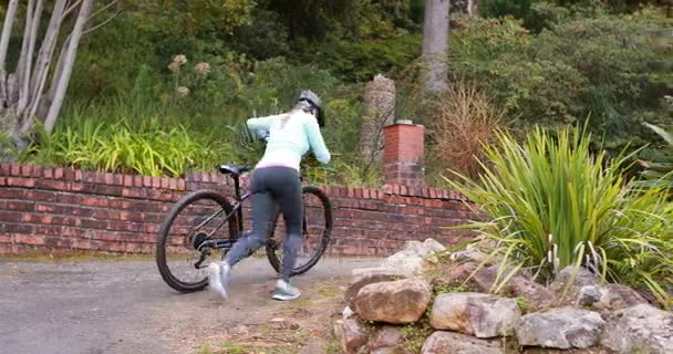 Female cyclist walking with mountain bike — Stock Video