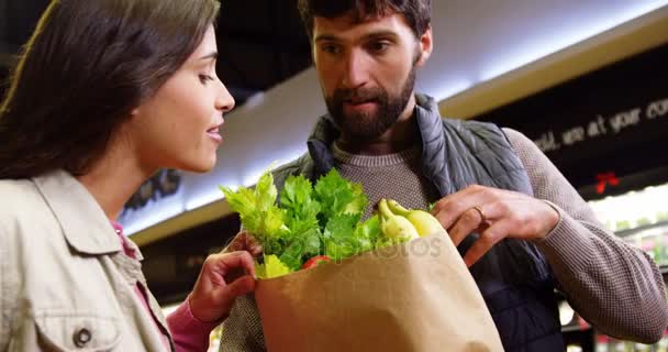 Paar winkelen voor groenten in de biologische sectie — Stockvideo