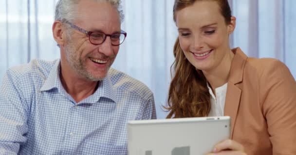 Zakenvrouw en medewerker bespreken over digitale tablet — Stockvideo