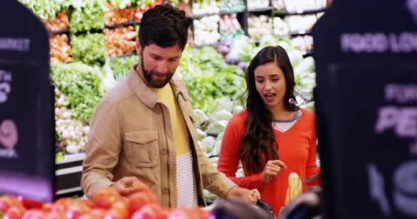 Pareja seleccionando verduras de la sección orgánica — Vídeos de Stock