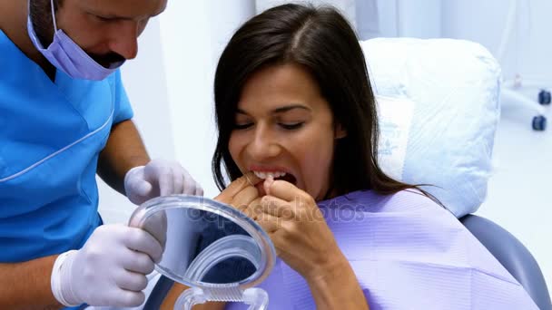 Θηλυκός ασθενής, καθαρισμός με οδοντικό νήμα τα δόντια — Αρχείο Βίντεο