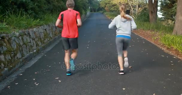 Casal jogging em estrada aberta — Vídeo de Stock