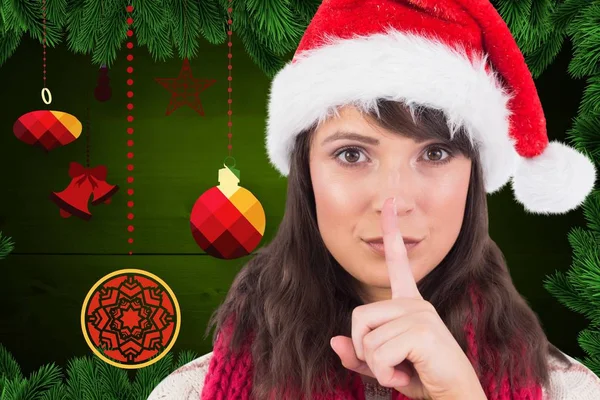 Vrouw in kerstmuts met een vinger op de lip — Stockfoto