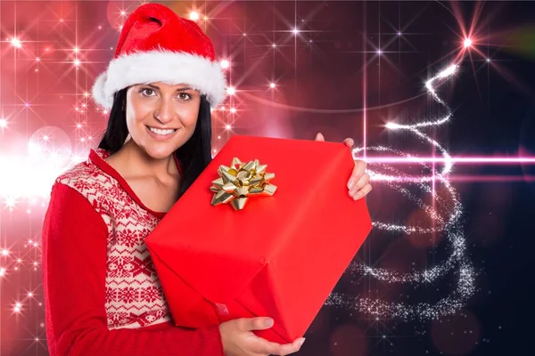 Mujer en sombrero de santa celebración de un regalo de Navidad — Foto de Stock