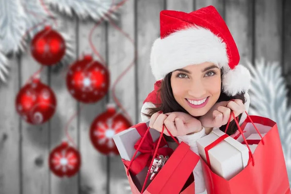 Vrouw in KERSTMUTS holding zakken met geschenken — Stockfoto