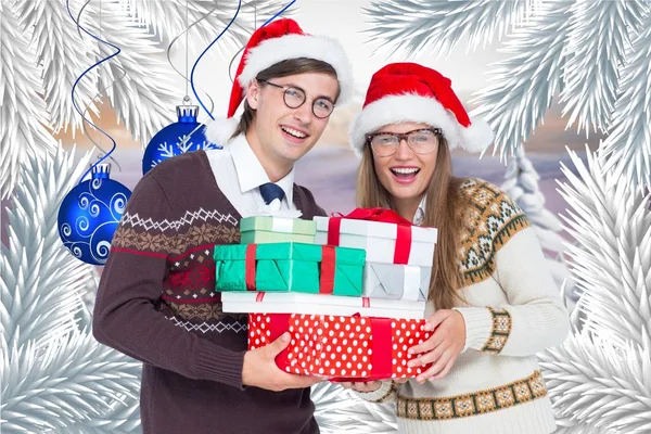 Pár v santa hat drží zásobníku dárkových krabiček — Stock fotografie
