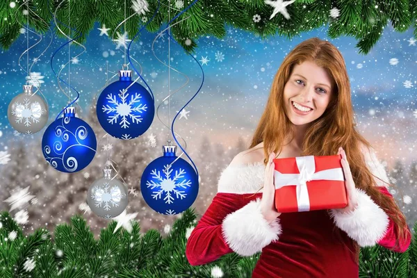 Frau mit Weihnachtsmütze zeigt ein Weihnachtsgeschenk — Stockfoto