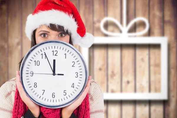 Donna in cappello Babbo Natale volto di copertura dietro l'orologio — Foto Stock