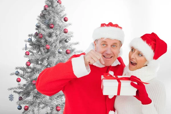 Coppia in cappello Babbo Natale con in mano una confezione regalo — Foto Stock