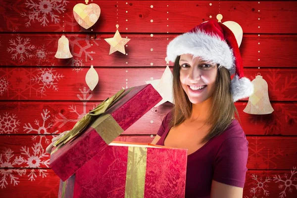 Donna in cappello da Babbo Natale aprendo una confezione regalo — Foto Stock