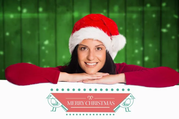 Frau mit Weihnachtsmütze lehnt an Plakat — Stockfoto
