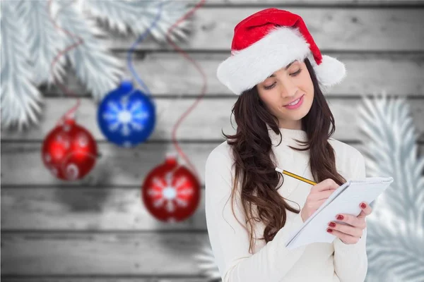 Vrouw in KERSTMUTS schrijven in Kladblok — Stockfoto