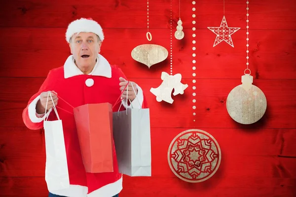 Homem em Santa fantasia segurando sacos de compras — Fotografia de Stock