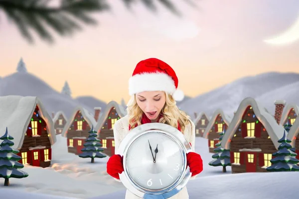 Shocked woman in santa hat holding a wall clock — Stock Photo, Image