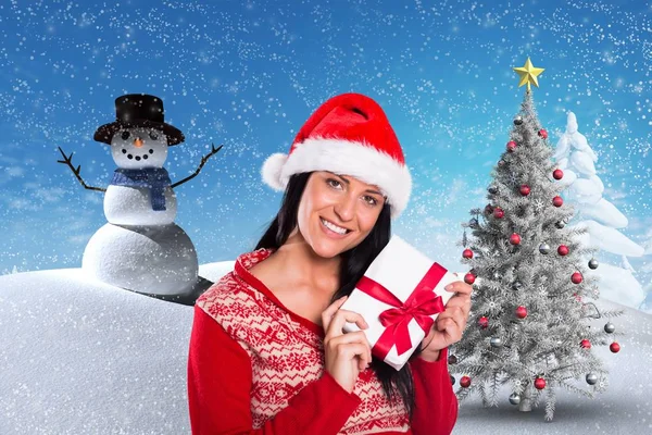 Frau mit Weihnachtsmütze hält Weihnachtsgeschenk in der Hand — Stockfoto