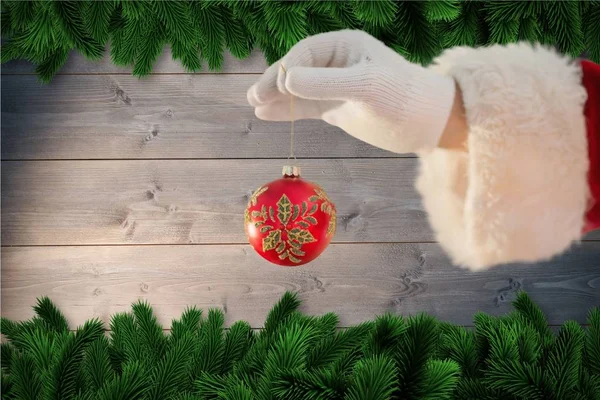 Santa claus holding christmas bauble — Stock Photo, Image