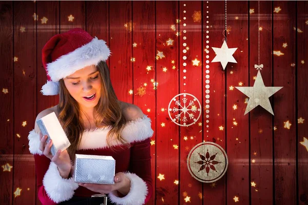 Kvinna i santa hatt tittar på julklapp — Stockfoto