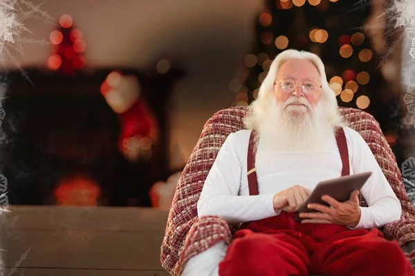 Weihnachtsmann mit Tablet zu Hause — Stockfoto