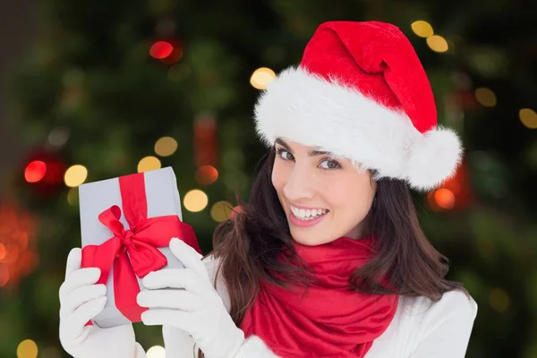 Frau mit Weihnachtsmütze hält Weihnachtsgeschenk in der Hand — Stockfoto