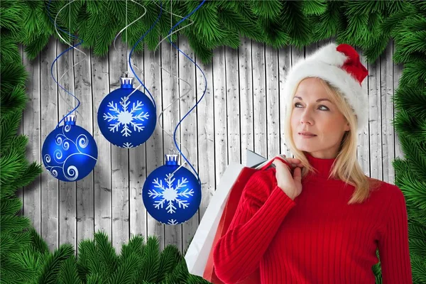 Vrouw in Kerstman hoed, bedrijf shopping tassen — Stockfoto