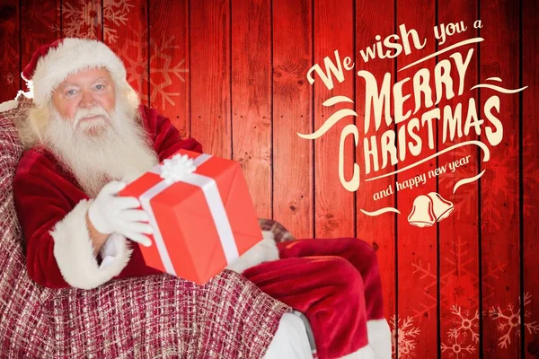 Santa claus holding christmas gift — Stock Photo, Image