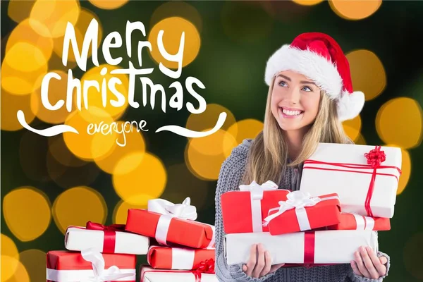 Frau mit Weihnachtsmannhut hält Geschenkboxen in der Hand — Stockfoto