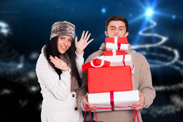 Couple holding stack of christmas gifts — Stock Photo, Image