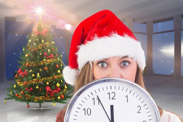 Mujer en santa hat cubriendo la cara detrás del reloj —  Fotos de Stock