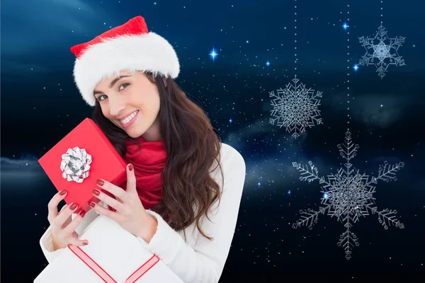 Noel Baba şapkalı kadın Noel hediyesi taşıyor. — Stok fotoğraf