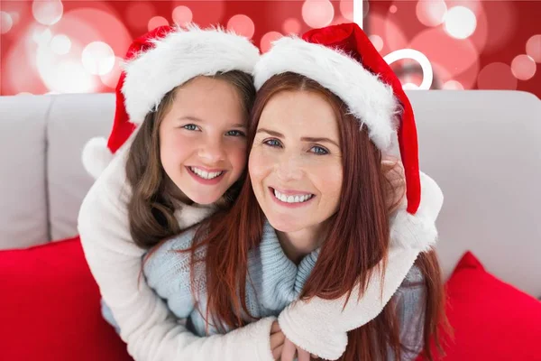 Moeder en dochter in santa claus hoeden — Stockfoto
