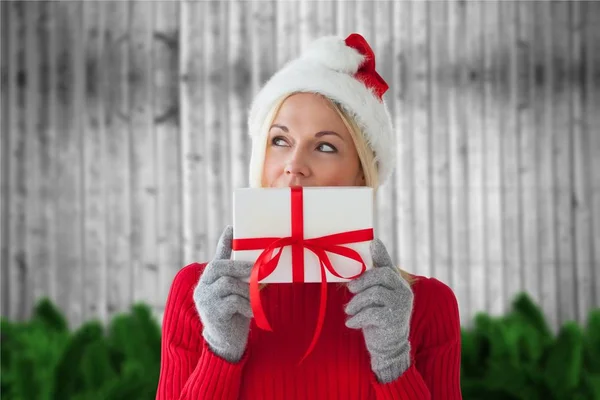 Frau mit Weihnachtsmütze hält Weihnachtsgeschenk in der Hand — Stockfoto