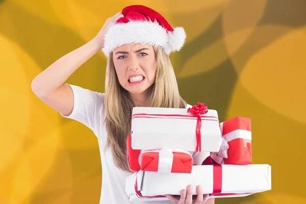 Femme frustrée dans le chapeau santa tenant pile de cadeaux — Photo