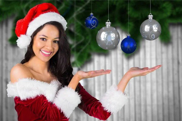 Kvinna i santa dräkt visar julgranskulor — Stockfoto