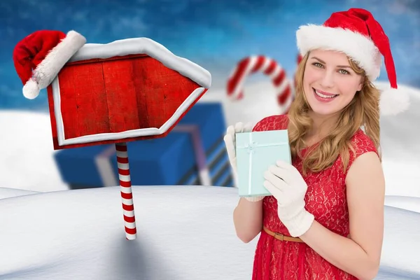 Žena v klobouku santa držící vánoční dárek — Stock fotografie