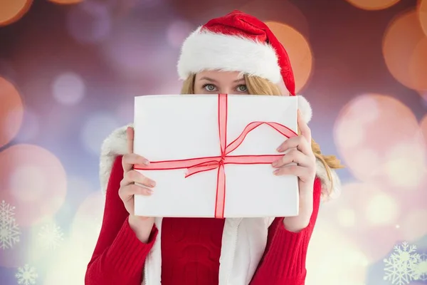 Žena v Santa klobouku drží vánoční dárek — Stock fotografie