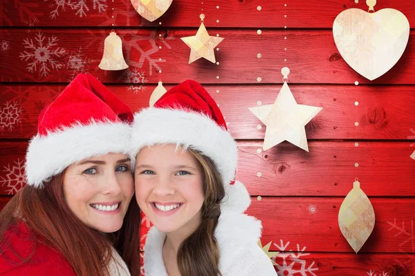 Mutter und Tochter in Weihnachtsmannmützen — Stockfoto