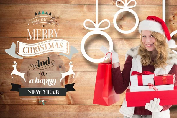 Frau mit Weihnachtsmütze hält Weihnachtsgeschenke in der Hand — Stockfoto